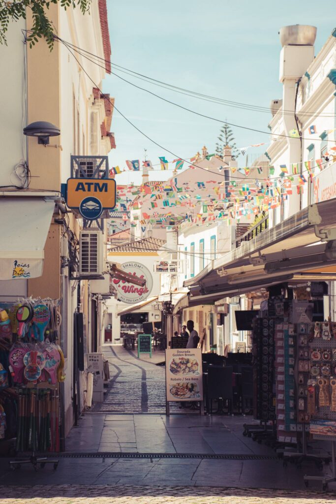 Lively pedestrian street in Albufeira with bunting and souvenir shops