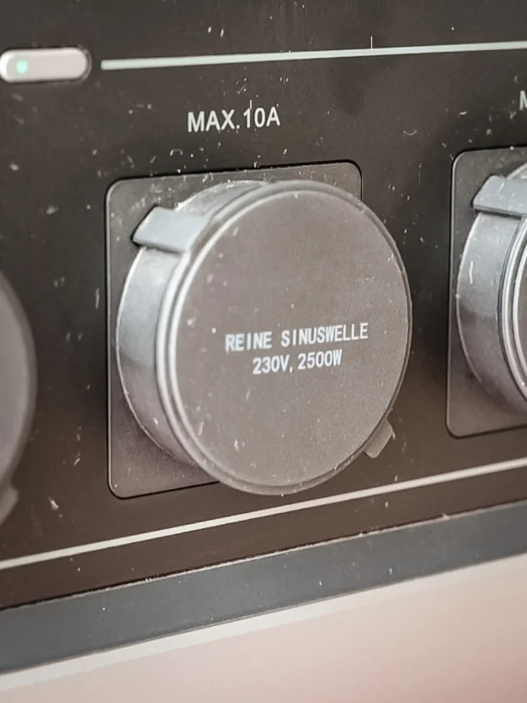 Close-up of an AC power socket of the AllPowers R2500 with its round silicone cover REINE SINUSWELLE 230V 2500W, individual anti-oxidation protection.