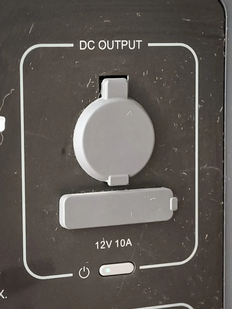 DC output of the AllPowers R2500: 12V 10A car cigarette lighter socket and DC port, protected by silicone covers.