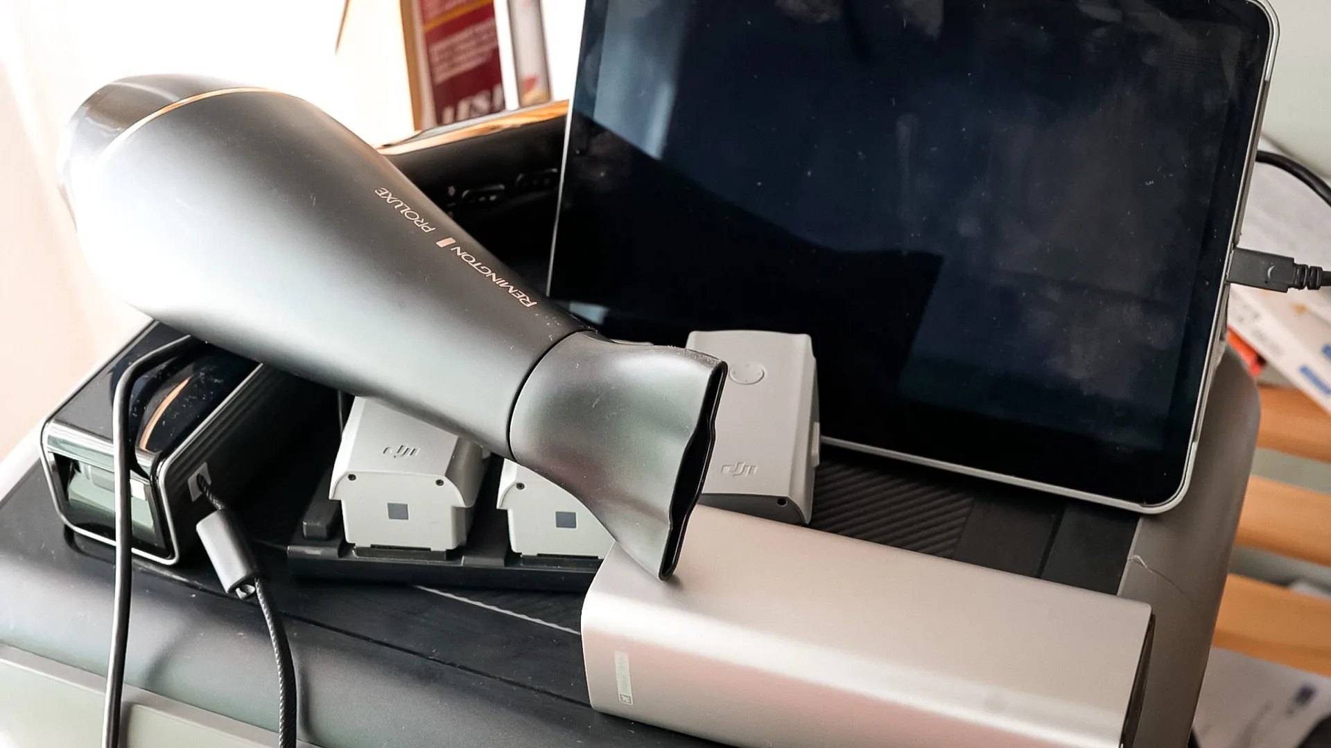 Cumulative load test of the AllPowers R2500: hairdryer, iPad, power bank, and DJI drone batteries plugged in at the same time.