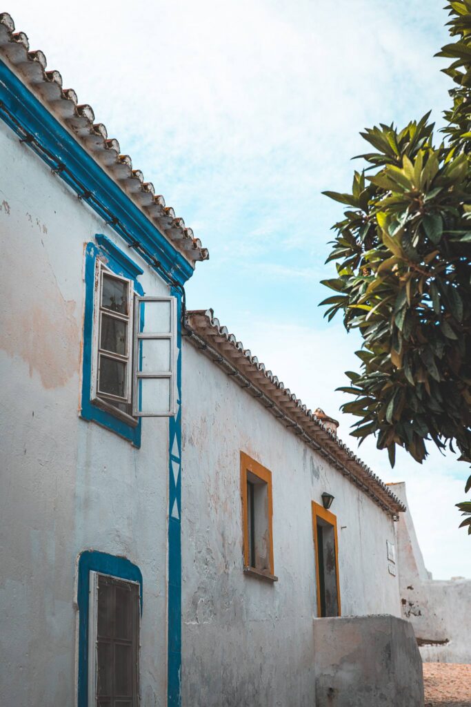 Traditional house with whitewashed walls and colorful frames in Cacela Velha, Algarve