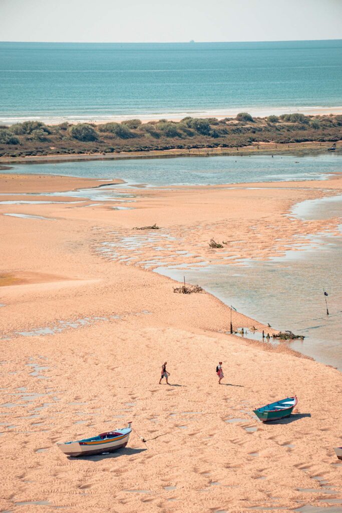 Cacela Velha beach at low tide with two colorful boats, Ria Formosa Algarve
