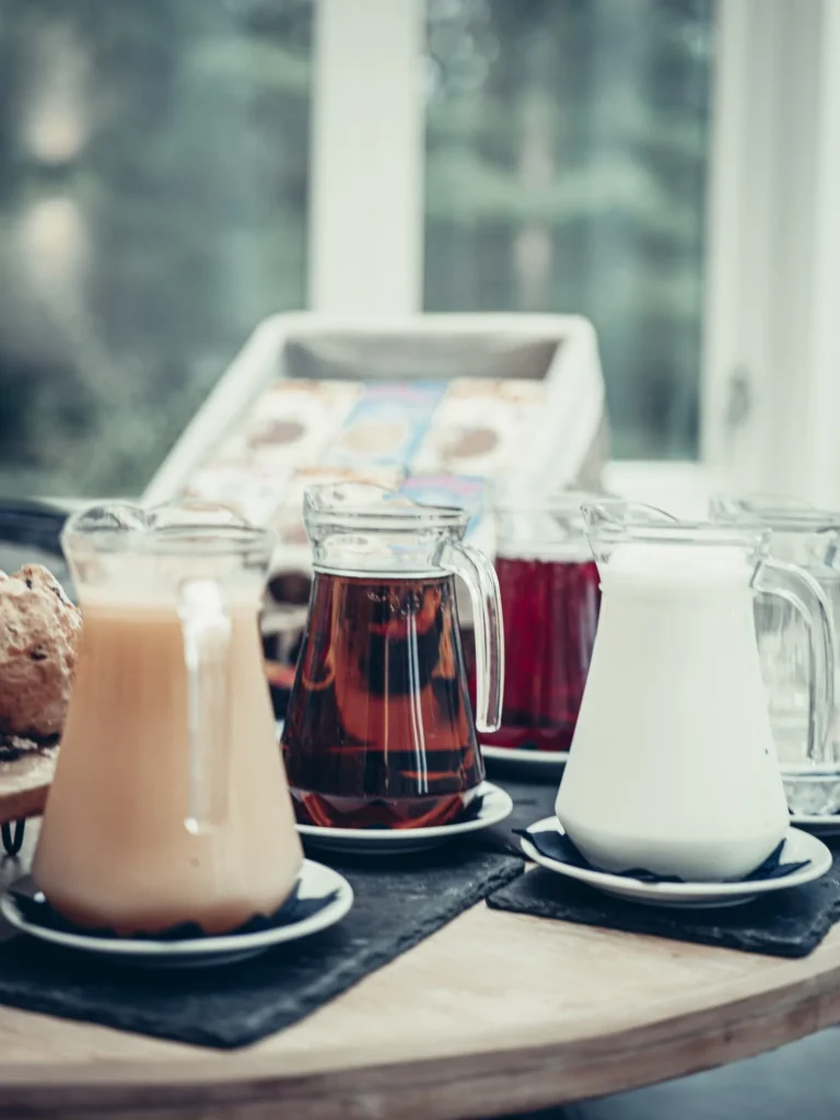 Breakfast at the Allan Park Hotel in Stirling with jugs of milk, tea, and juice placed on a table in front of a bright window.