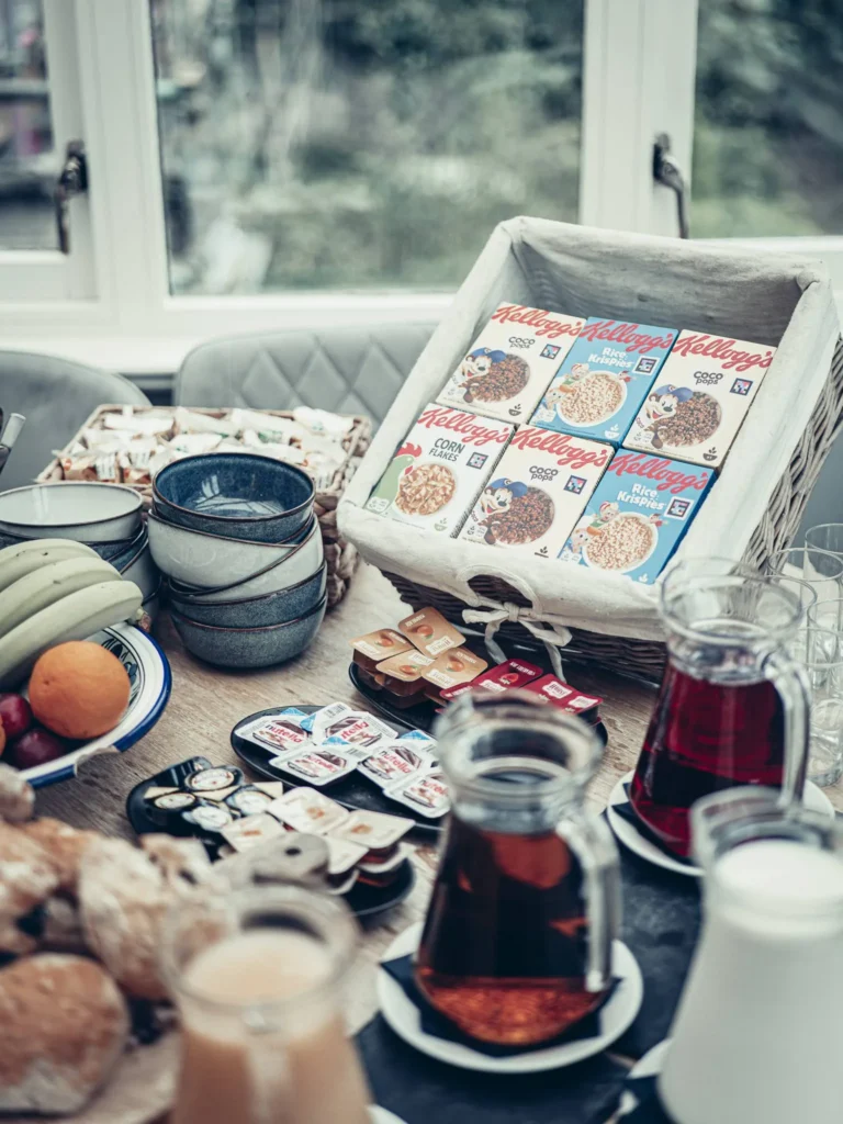 Buffet breakfast at the Allan Park Hotel in Stirling, featuring cereals, fruits, drinks, and jams, presented on a table by a bright window in August 2026.