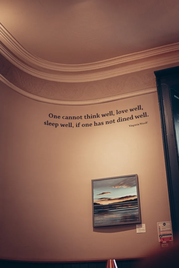 Interior wall of the Allan Park Hotel restaurant in Stirling, featuring a quote from Virginia Woolf and a painting depicting a Scottish landscape.