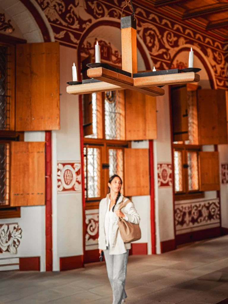Caroline walking through a richly decorated room at Stirling Castle, with wood panelling and painted patterns on the walls.