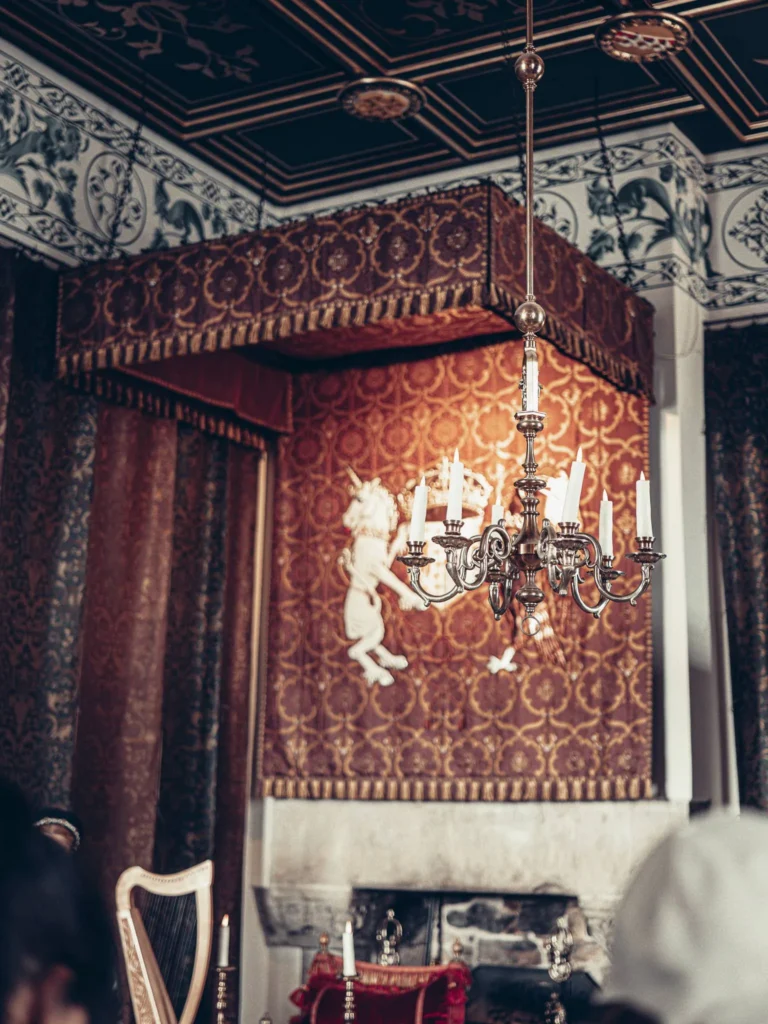 A richly decorated room at Stirling Castle, with woven hangings, an old chandelier and a harp in the foreground.