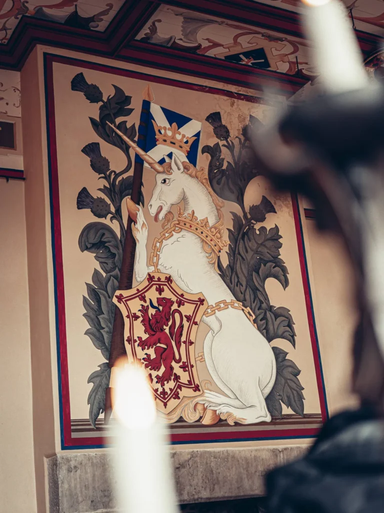 A wall painting of a crowned unicorn holding a Scottish shield, inside Stirling Castle, Scotland.