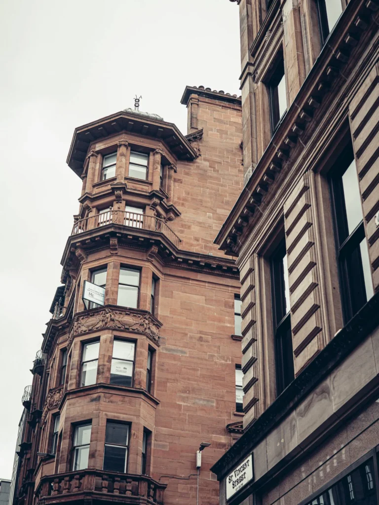 Victorian buildings in blond and red sandstone with bay windows on St Vincent Street, in the centre of Glasgow.