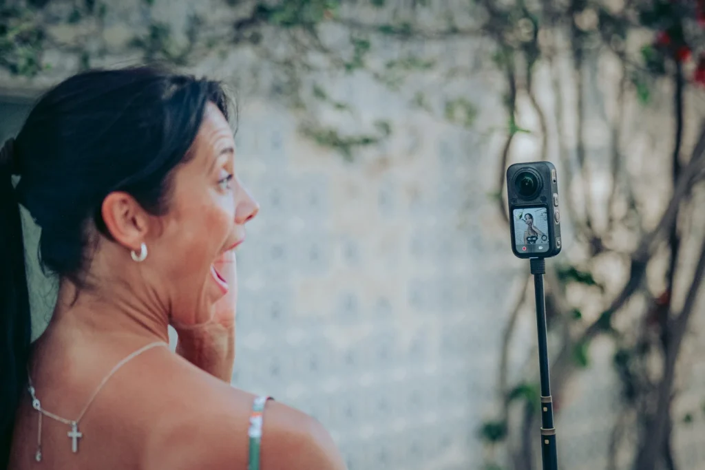 Caroline tests the Insta360 X6 in selfie mode, surprised in front of the camera screen
