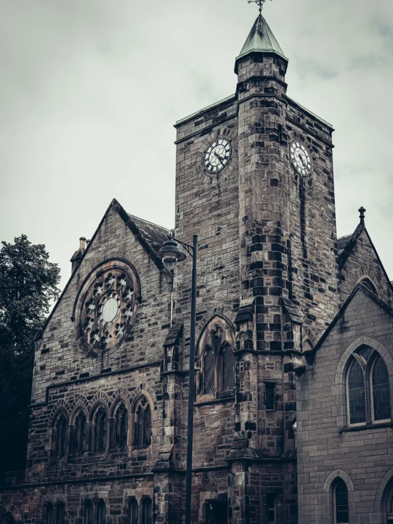 Stone facade of the Church of the Holy Rude, in the old town of Stirling: large rose window and clock tower. It is a church, not a cathedral.