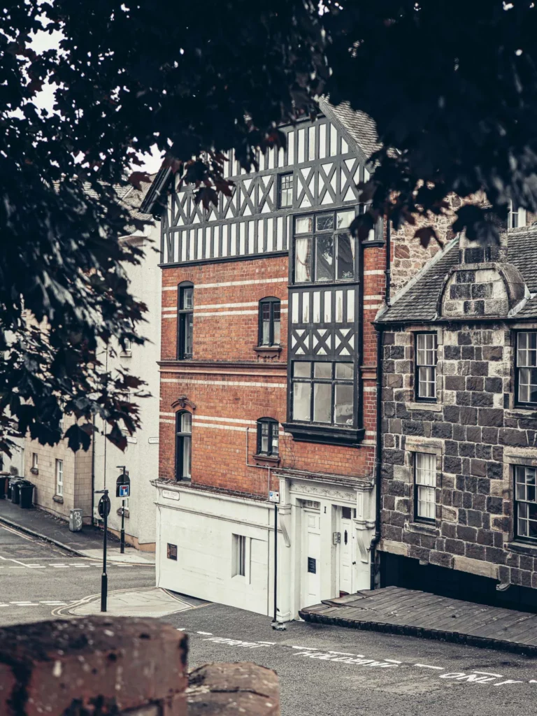 Stone and brick facades on a sloping street in the old town of Stirling, vintage lamppost at the corner of the street.