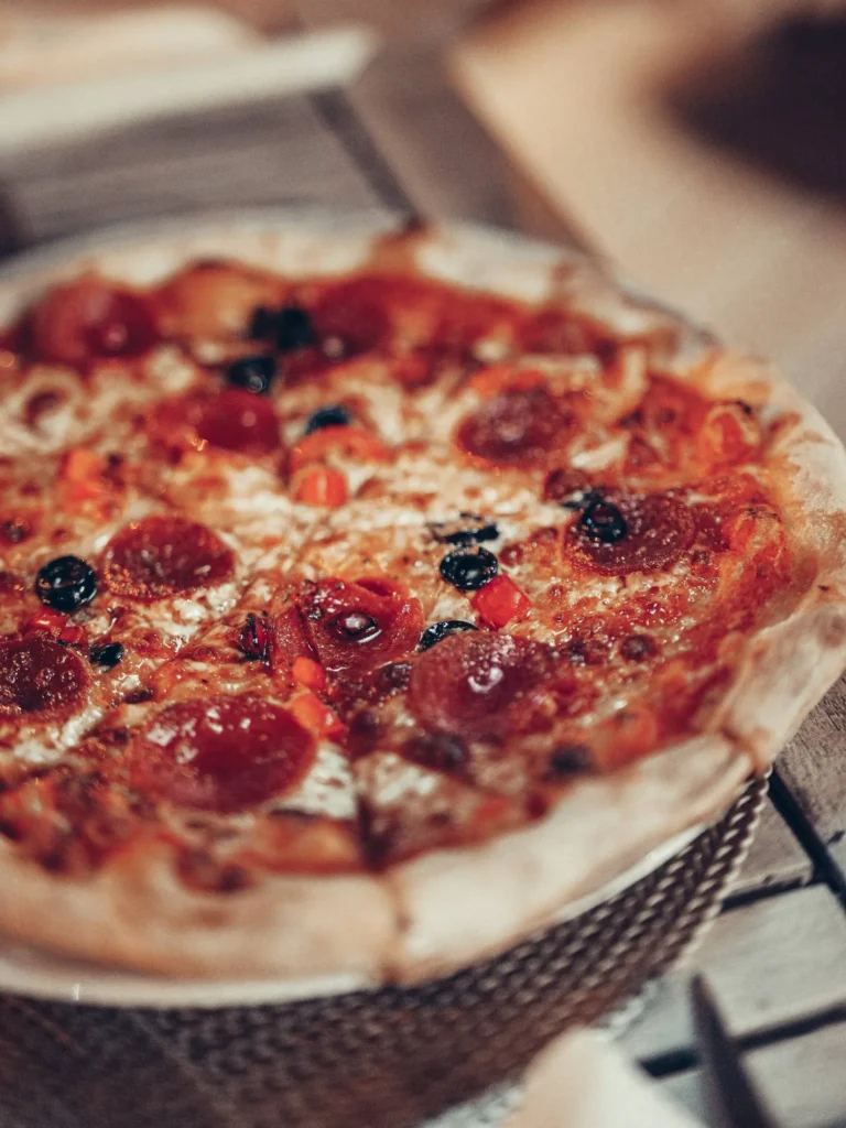 Wood-fired pizza served on a wooden table in a restaurant in Tavira, Algarve.
