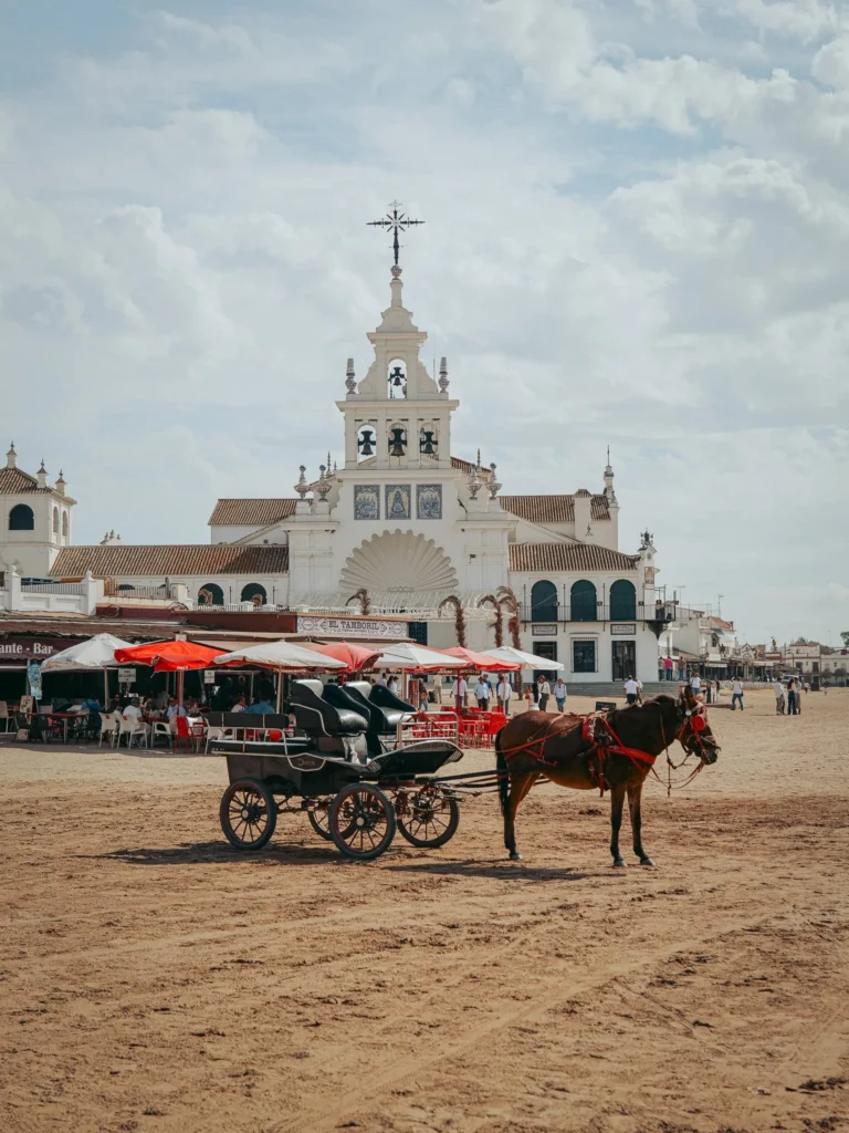 Carrozza sulla sabbia con il santuario del Rocío e le terrazze sullo sfondo