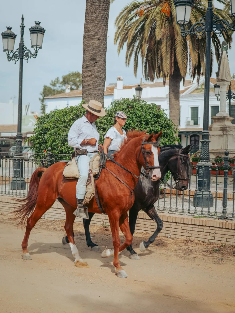 Due visitatori a cavallo in una strada di sabbia a El Rocío