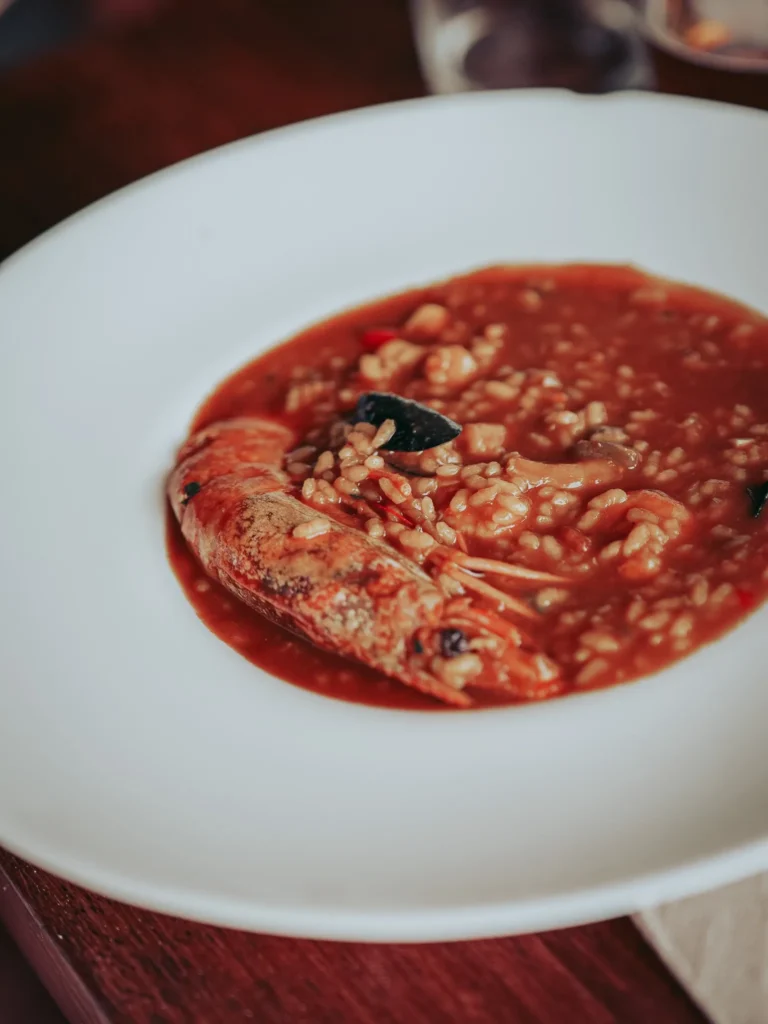 Piatto fondo di riso ai frutti di mare con brodo rosso e un gamberone da La Tata