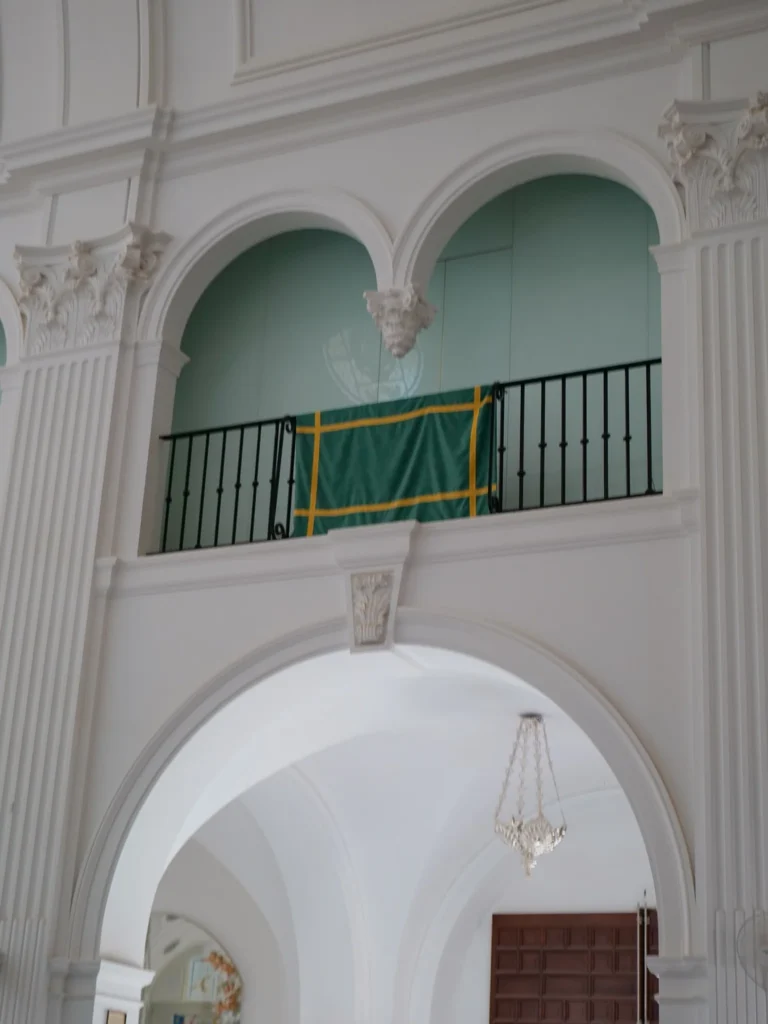 Drappo verde con bordi gialli ripiegato su una balaustra del santuario del Rocío